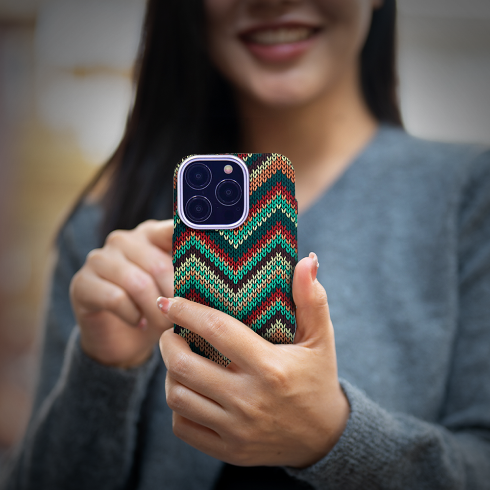 A woman proudly holds her phone adorned with a bright, colorful design, highlighting the iPhone 16 Case available at grunxstore.com.