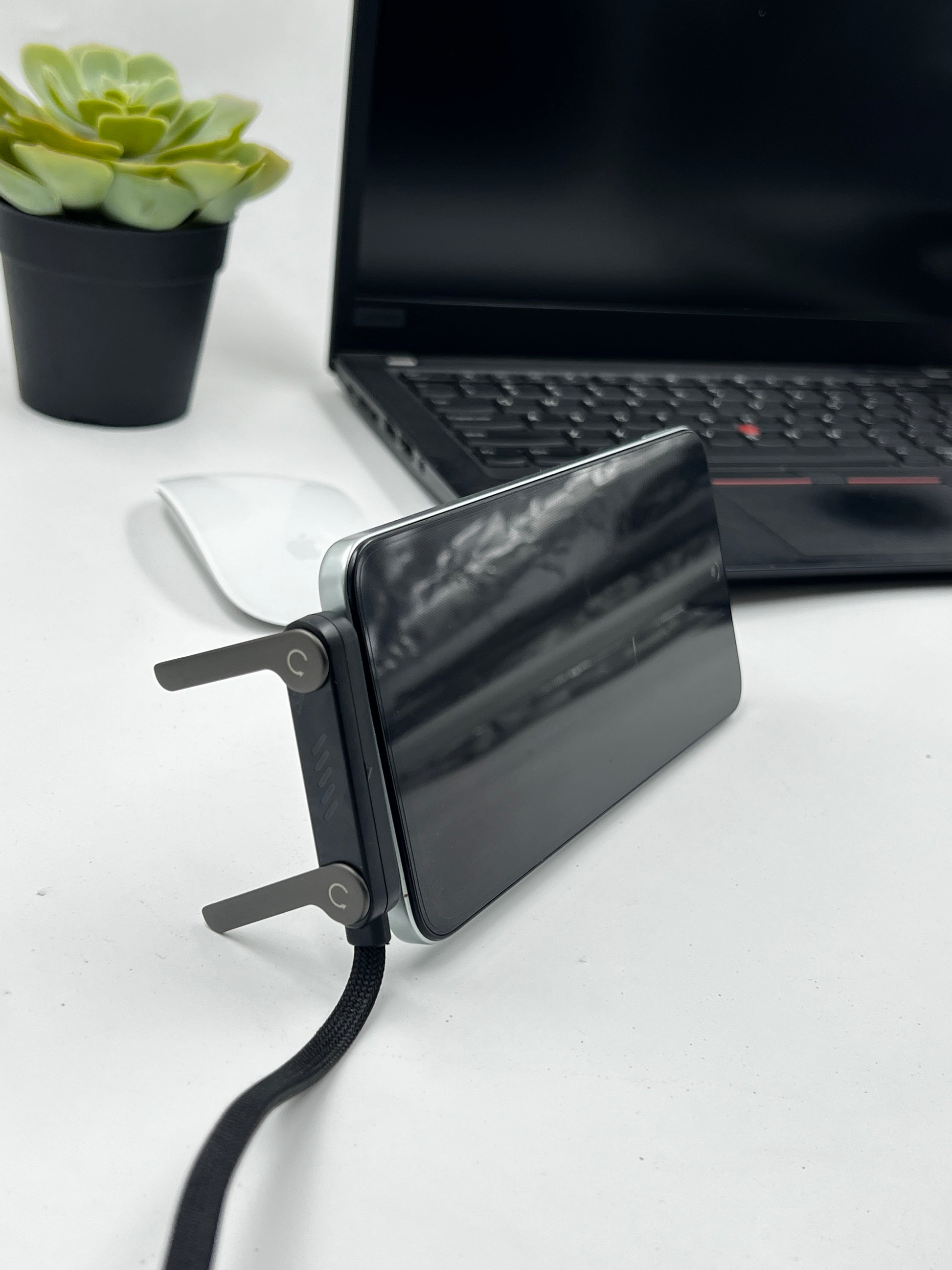 GRUNX TikTok cable invisible stand folded flat showing slim profile alongside MacBook and Samsung Galaxy S24