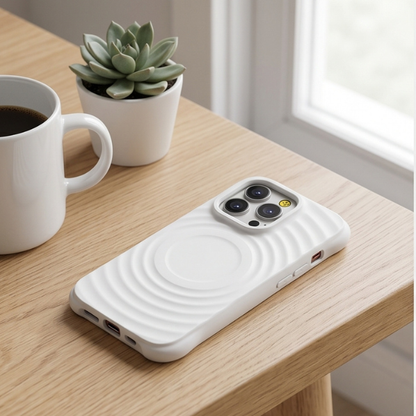 White wavy textured iPhone case with gold camera ring displayed on wooden desk next to coffee mug and succulent plant in minimalist workspace