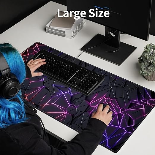 Female gamer using large neon geometric polygon extended gaming mouse pad with RGB keyboard and dual monitors setup