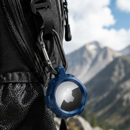 Apple AirTag in a blue carabiner clip case attached to the zipper strap of a black backpack, shown against a scenic mountain landscape background