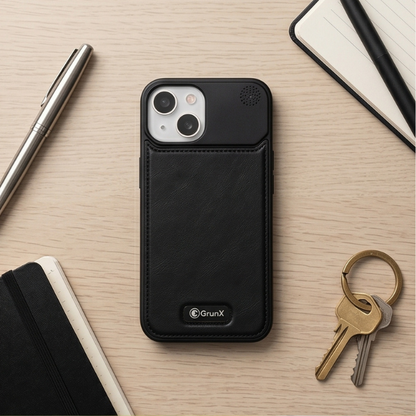Black leather iPhone case with protective design displayed on wooden tray next to reading glasses and metal pen in premium workspace