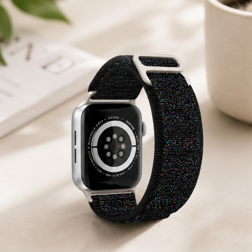 Apple Watch with silver aluminum case and a black woven nylon sport loop band displayed in a bright lifestyle setting with soft natural lighting