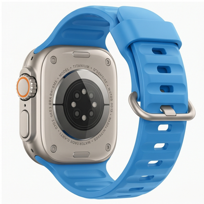 Apple Watch Ultra with a light blue silicone sport band shown on a neutral background, highlighting the titanium case and band connector detail