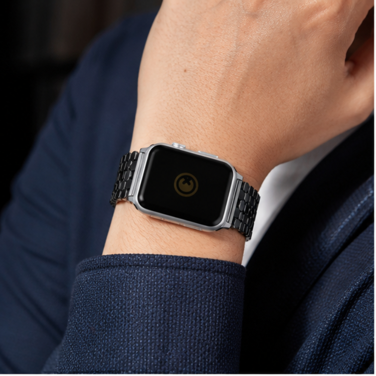 Person in a navy blue suit wearing Apple Watch with silver stainless steel jubilee link band on their wrist