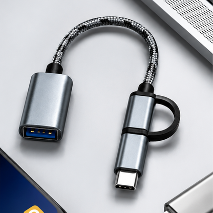 GrunX Twinport 2-in-1 OTG cable with USB-C and Micro-USB connectors alongside a USB-A female adapter, styled flat lay on a light gray surface with a blue accent card.