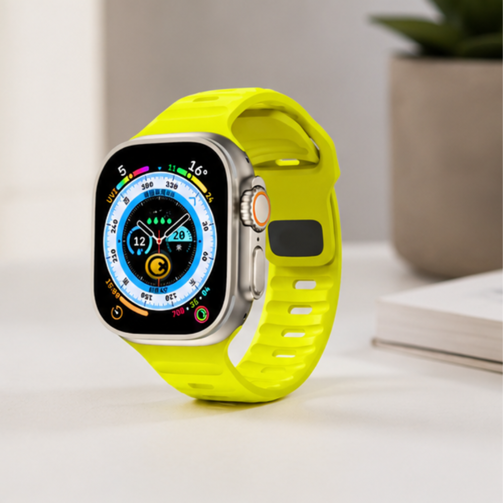Apple Watch Ultra with neon yellow silicone sport band displayed on a white surface, showing a vibrant watch face