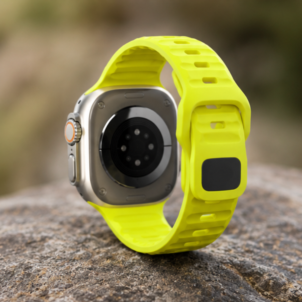 Rear view of Apple Watch Ultra with neon yellow silicone sport band standing upright on a rock, showing the back sensors and band connector