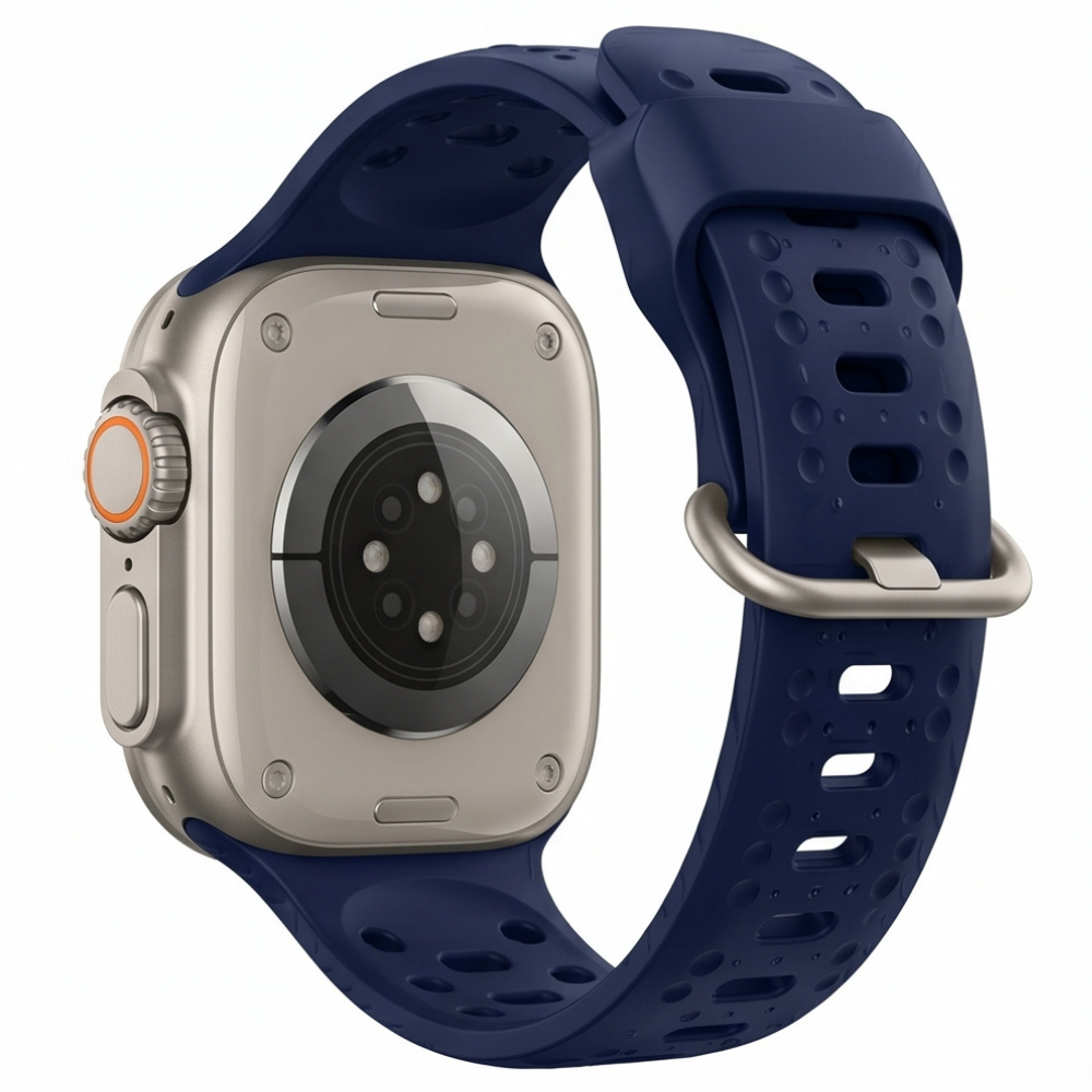 Side profile close-up of an Apple Watch Ultra titanium case with a bold navy blue silicone sport band, highlighting the orange action button and robust casing