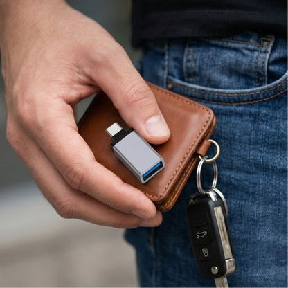 Compact Type-C to USB-A OTG metal adapter held in hand alongside wallet and car keys showing portable size