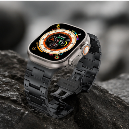 Apple Watch Ultra with black stainless steel link band resting on dark wet rocks outdoors