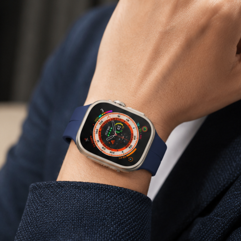 Close-up of a person wearing Apple Watch Ultra with navy blue silicone sport band on their wrist against a marble surface