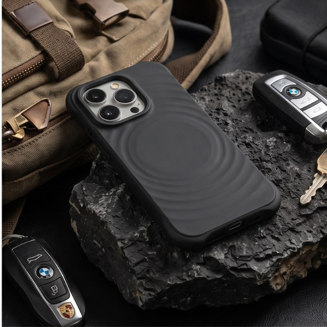 Black rugged iPhone case placed on a rock alongside car keys and tactical gear